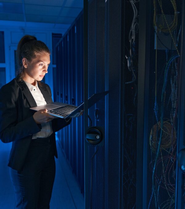 Confident system administrator working on laptop in data center
