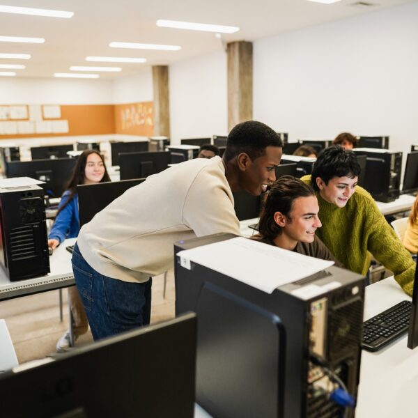 Young multiracial students using computers during business class at school Young multiracial students using computers during business class at school