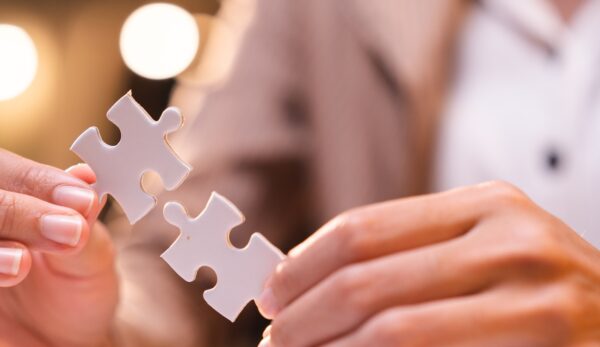 Concept of integration and startup with puzzle pieces merger with teamwork of business worker