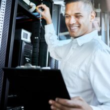 Server room, IT support and database with a man programmer working on a mainframe in a data center. Server room, IT support and database with a man programmer working on a mainframe in a data center.
