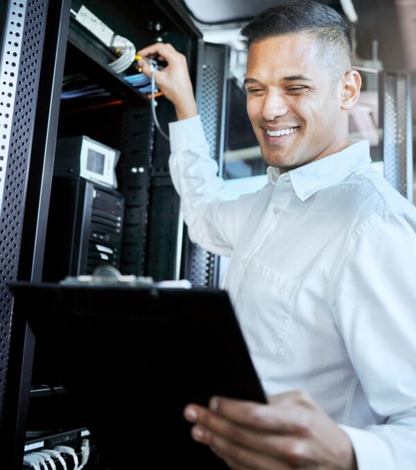 Server room, IT support and database with a man programmer working on a mainframe in a data center. Server room, IT support and database with a man programmer working on a mainframe in a data center.
